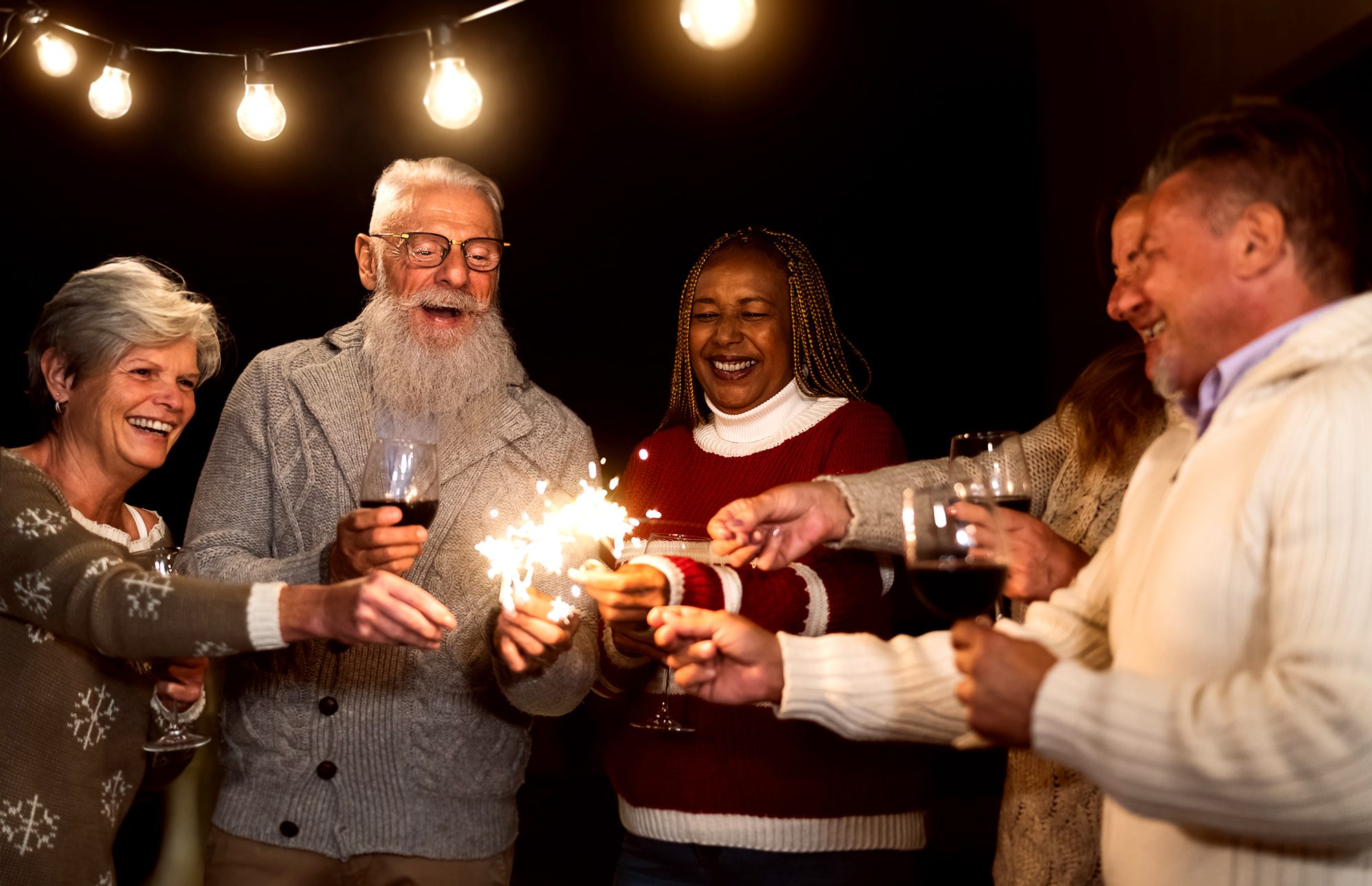 Happy seniors having fun celebrating holidays drinking wine and